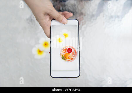 Dame prendre photo de Recette du cocktail mai tai nom mai thai ou dans le monde en faveur de l'alcool doux cocktail - boire avec les gens aiment se détendre vacances Banque D'Images