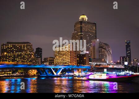 Photo de nuit de la ville asiatique - lumière bleue pont au-dessus de Big River et de l'arrière-plan de construction à Bangkok en Thaïlande Banque D'Images