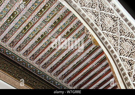 Détail de la sculpture sur stuc, sur fond de plafond en bois peint à la main. Palais Bahia, Marrakech Banque D'Images