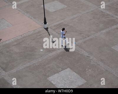 Nicaragua, Leon, Cenrtal Nord. Cathédrale, femme OU dame en utilisant son mobile cell correctif phne sur Facebook ou envoyer des textos ou google maps Banque D'Images