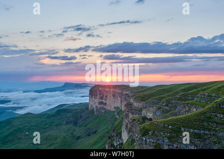 Coucher du soleil dans les montagnes. Le soleil qui illumine la montagne, le brouillard et les nuages. Banque D'Images