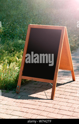 Un tableau noir sur socle bois pour un menu de restaurant dans la rue. Menu vide sur rue. Menu vide sur rue sur la pub ou restaurant Banque D'Images