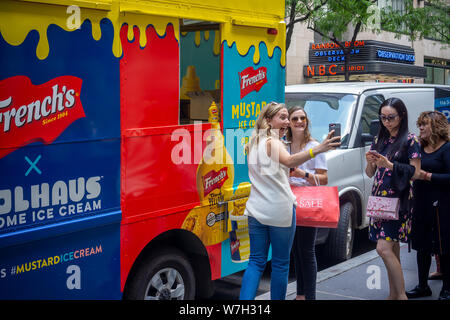 Les amoureux de la crème glacée et les amateurs de moutarde affluent à Midtown Manhattan pour boules de glace à la moutarde French's le Jeudi, août 1, 2019. Une collaboration avec le quartier branché de Coolhaus marque de crème glacée la crème glacée moutarde moutarde French's utilise pour créer ses il est alarmant de couleur jaune vif. Le français est une marque de McCormick. (© Richard B. Levine) Banque D'Images