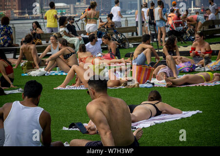 La génération y foule dans le parc de Domino quartier de Williamsburg à Brooklyn à New York pour faire cuire au soleil le dimanche, Août 4, 2019. (© Richard B. Levine) Banque D'Images