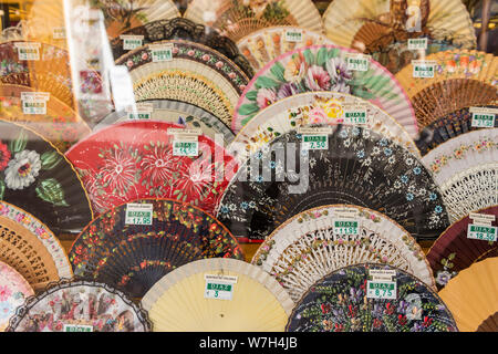 Une collection de fans espagnols traditionnels à la vente et sur l'écran avec des prix dans une vitrine à Séville Espagne Banque D'Images