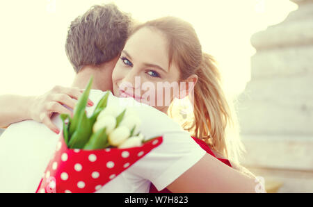 Young blonde woman embracing man on date en plein air, selective focus Banque D'Images