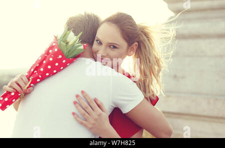 Young blonde woman embracing man sur la date à l'extérieur Banque D'Images