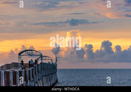 Lever de soleil colorés ornent les nuages au-delà de l'horizon Lake Worth jetée à Lake Worth Beach dans le comté de Palm Beach en Floride. (USA) Banque D'Images