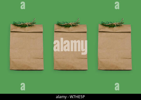 Sacs en papier brun sur un fond vert. Boîtes vides avec la direction générale de l'épinette. Fort pour un cadeau ou la restauration rapide. Sac de papier Banque D'Images