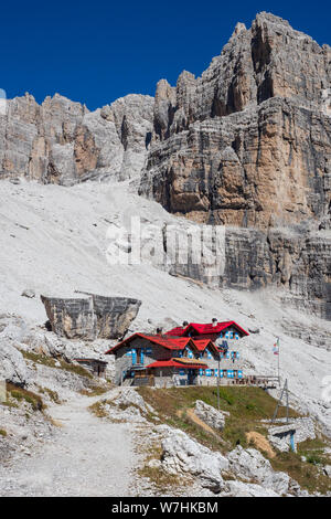 Avec les sacs à dos de randonnée touristique en montagne randonnée sur journée d'été. Homme randonnée dans les beaux paysages de montagne. Grimpeur et chalet de montagne à Dolomites Banque D'Images