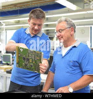 Le contrôle de la qualité dans l'ingénierie dans le travail d'équipe - les employés lors d'une réunion - la production de l'électronique dans une usine industrielle moderne Banque D'Images
