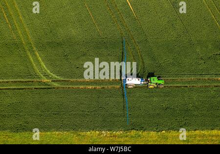 Vue aérienne du tracteur, la pulvérisation des insecticides sur un champ, Soester Borde, Rhénanie du Nord-Westphalie, Allemagne Banque D'Images