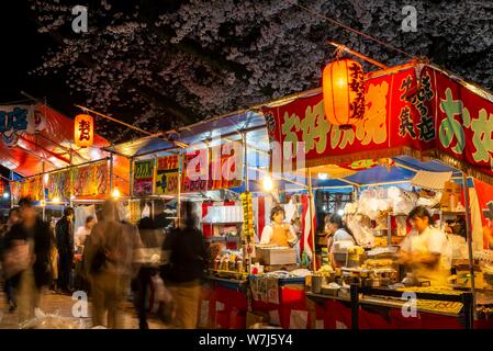 Stands de nourriture avec la nourriture japonaise la nuit, cerisiers en fleurs au printemps, Hanami Fest, le parc Ueno, Taito City, Tokyo, Japon Banque D'Images