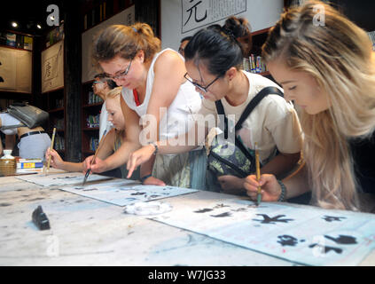 Les étudiants étrangers apprendre à écrire calligraphie chinoise au cours d'une activité au village, Shangjing Tangxi ville, dans la ville de Jinhua, East China's Zhejiang bauvin Banque D'Images