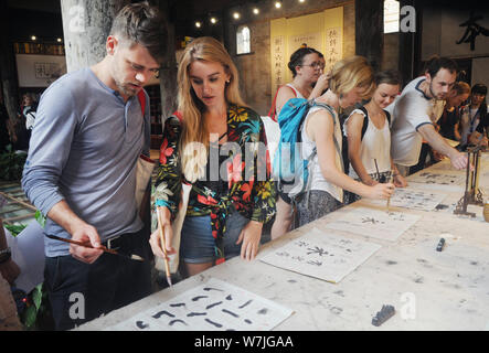 Les étudiants étrangers apprendre à écrire calligraphie chinoise au cours d'une activité au village, Shangjing Tangxi ville, dans la ville de Jinhua, East China's Zhejiang bauvin Banque D'Images