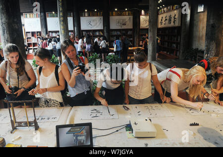 Les étudiants étrangers apprendre à écrire calligraphie chinoise au cours d'une activité au village, Shangjing Tangxi ville, dans la ville de Jinhua, East China's Zhejiang bauvin Banque D'Images