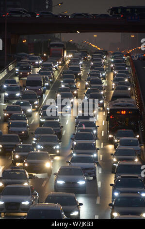 Masses de véhicules se déplacent lentement sur une route dans un embouteillage aux heures de pointe avant la fête de la Mi-automne et la Journée nationale de vacances d'été à Beijing, Banque D'Images
