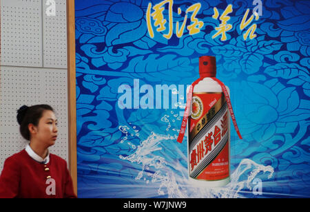 --FILE--un employé chinois passe devant une publicité pour Kweichow Moutai lors d'une exposition à Tianjin, Chine, 28 octobre 2012. Kweichow Moutai, Banque D'Images