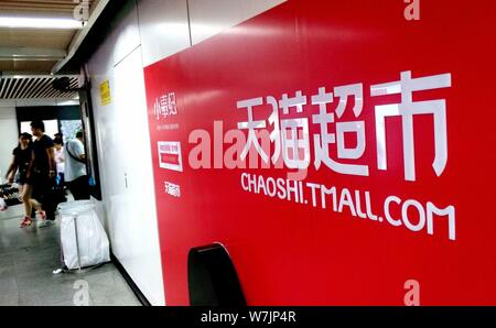 --FILE--passagers à pied passé une annonce de publicité pour les achats en ligne de la plate-forme Tmall.com Alibaba Group à une station de métro à Shangha Banque D'Images