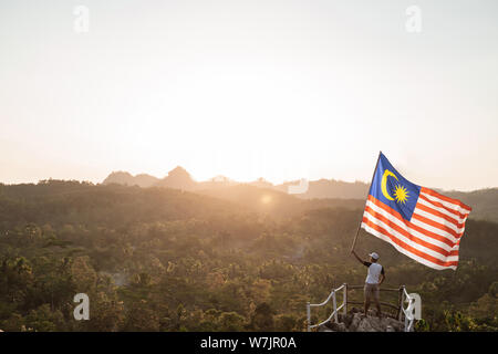 Asian male avec drapeau célébrant le jour de l'indépendance malaisienne Banque D'Images