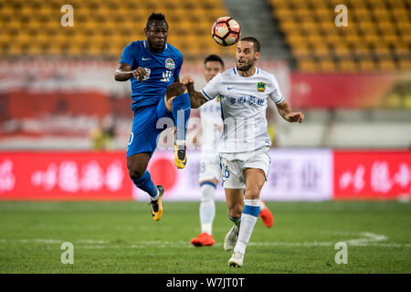 Joueur de football espagnol Mario Suarez, droite, de Guizhou Hengfeng Zhicheng, défis joueur de football Christian Bassogog de Henan Jianye je Banque D'Images