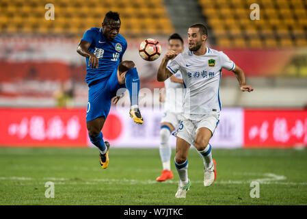 Joueur de football espagnol Mario Suarez, droite, de Guizhou Hengfeng Zhicheng, défis joueur de football Christian Bassogog de Henan Jianye je Banque D'Images