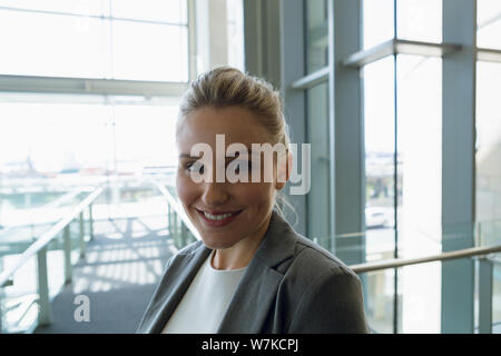 Happy Businesswoman standing dans le couloir au bureau Banque D'Images