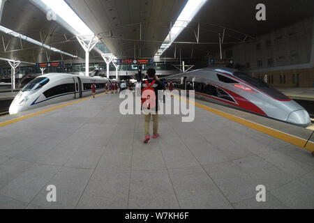 Un 'haut-débit' Fuxing bullet train sur le chemin de fer interurbain Beijing-Tianjin, droite, et d'un CRH (China railway High-speed bullet train) sont à Banque D'Images