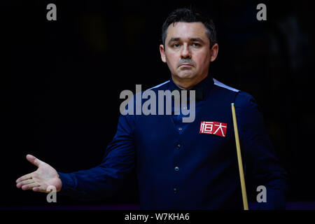 Alan McManus d'Écosse réagit après avoir joué un coup de Ding Junhui de Chine dans leur deuxième tour au cours de la Chine 2017 Championship Snooker à Banque D'Images