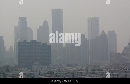 --FILE--immeubles-tours et gratte-ciel sont vu vaguement sur le toit d'un gratte-ciel dans le smog lourds à Nanjing, ville de Jiangsu est bauvin Banque D'Images