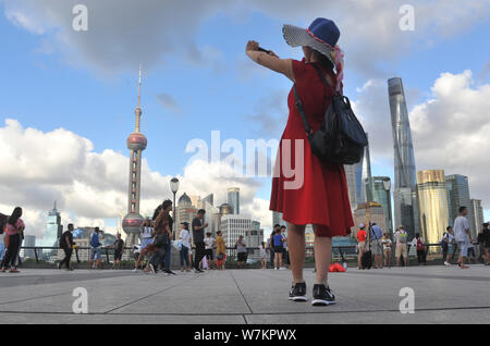 Les touristes chinois visite la promenade sur le Bund, le long de la rivière Huangpu et contre l'avis du financier de Lujiazui avec des immeubles de grande hauteur et Banque D'Images
