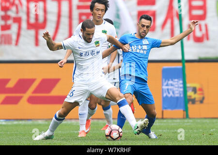 Joueur de football israélien Eran Zahavi, droite, de Guangzhou R&F, joueur de football espagnol défis Mario Suarez de Guizhou Hengfeng Zhichen Banque D'Images