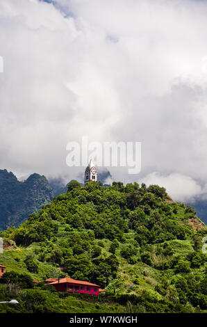 Belle vue sur le paysage de montagne unique à Sao Vincente, Madeira, Portugal, Europe. Une petite église se dresse sur une colline dans les nuages. Banque D'Images