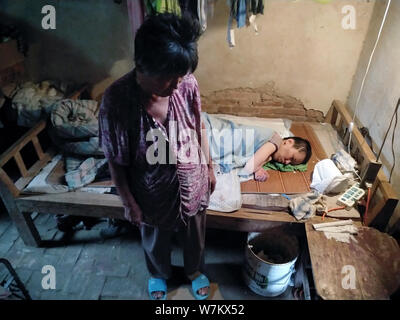 La fille, de retour, de 71-year-old femme chinoise Han Xiurong, avant, qui a été habillé comme Pikachu dans les rues pour recueillir de l'argent pour le traitement de Banque D'Images