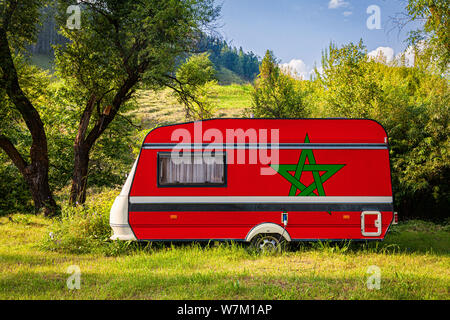 Une voiture remorque, d'une autocaravane, peint dans le drapeau national du Maroc est stationné dans une zone montagneuse. Le concept du transport routier, le commerce, l'exportation et Banque D'Images