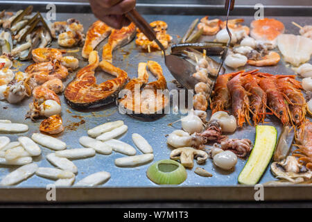 La main à l'aide du chef tout en spatule poêle assortiment de fruits de mer Banque D'Images