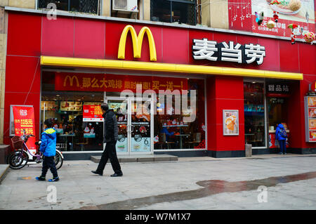 --FILE--piétons passent devant un restaurant de fast-food McDonald's dans la ville de Yichang, province du Hubei en Chine centrale, 10 décembre 2016. Plan de McDonald's Banque D'Images