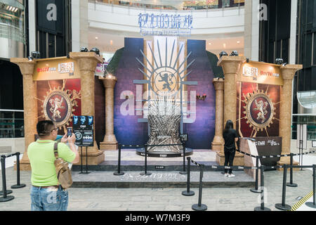 Les visiteurs de prendre des photos d'une réplique grandeur nature de la vie du fer à repasser trône de la série HBO Game of Thrones dans un centre commercial à Shanghai, Chine, le 9 août 201 Banque D'Images