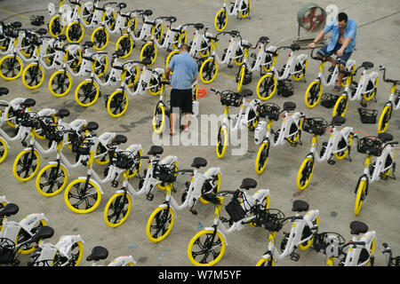 Vérifier les travailleurs chinois de vélos partagés smart Chinese location bouilloire pour toujours la queue à une usine à Shanghai, Chine, 24 août 2017. Shanghai Forever Banque D'Images