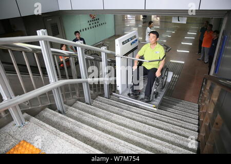 Un passager à mobilité réduite utilise la plate-forme élévatrice pour fauteuils roulants conçus pour les passagers handicapés est photographié à la sortie de la gare ouest de Beijing à Bei Banque D'Images