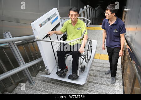 Un passager à mobilité réduite utilise la plate-forme élévatrice pour fauteuils roulants conçus pour les passagers handicapés est photographié à la sortie de la gare ouest de Beijing à Bei Banque D'Images