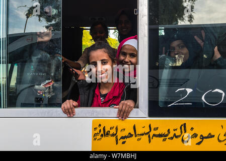 Aqaba, Jordanie - le 6 novembre 2017 : les écolières non identifiés sourire amical dans un autobus à Aqaba, Jordanie. Banque D'Images