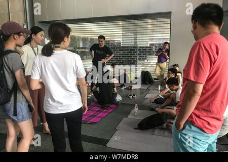 Les collectionneurs de la dette y compris certains de ses fournisseurs de partout dans le comté se coucher ou s'asseoir sur des couvertures et tapis de yoga au siège de Beijing à la Ch Banque D'Images