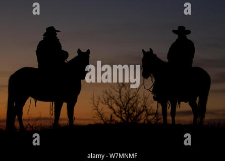 Silhouette de deux cowboys montés à l'aube, Wyoming, USA, février 2012, parution du modèle Banque D'Images