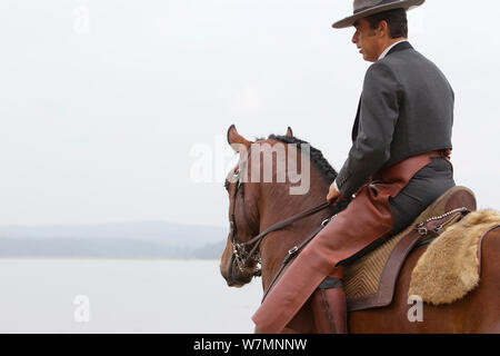 Cheval lusitanien, l'homme à cheval à côté de l'eau, l'étalon portant des vêtements traditionnels, Portugal, mai 2011, parution du modèle Banque D'Images
