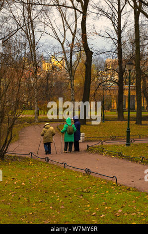 Saint Petersburg, Russie - 16 novembre 2018 : Trois personnes âgées engagées dans la marche nordique dans le parc sur un jour nuageux en fin d'automne Banque D'Images
