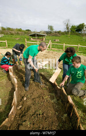 Les jeunes bénévoles aident à créer des lits de plantation élevé pour produire des denrées alimentaires, les pieds sur terre, projet environnemental Murton, Gower, dans le sud du Pays de Galles, UK 2009 Banque D'Images