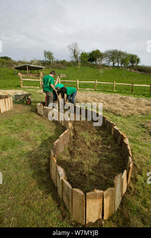 Les jeunes bénévoles aident à créer des lits de plantation élevé pour produire des denrées alimentaires, les pieds sur terre, projet environnemental Murton, Gower, dans le sud du Pays de Galles, UK 2009 Banque D'Images