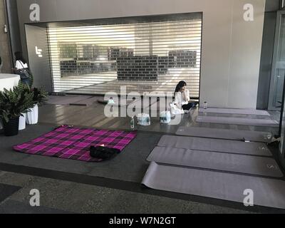 L'un des collectionneurs de la dette y compris certains de ses fournisseurs de partout dans le comté est assis sur un tapis de yoga au siège de Beijing tech L géant chinois Banque D'Images