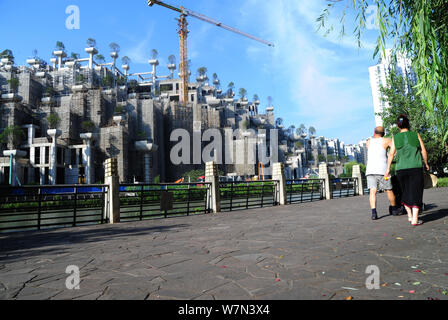 Les citoyens chinois à pied passé le nouveau projet immobilier que les développeurs sont des capacités dans le district le long de la Suzhou River avec arbres pla Banque D'Images